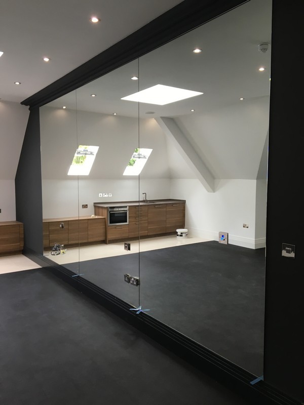 Frameless glass partition in loft conversion by Surbiton glaziers